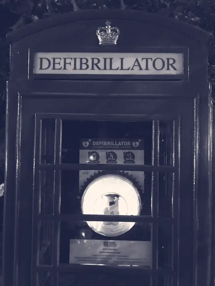 A public defibrillator installed in a red British telephone box