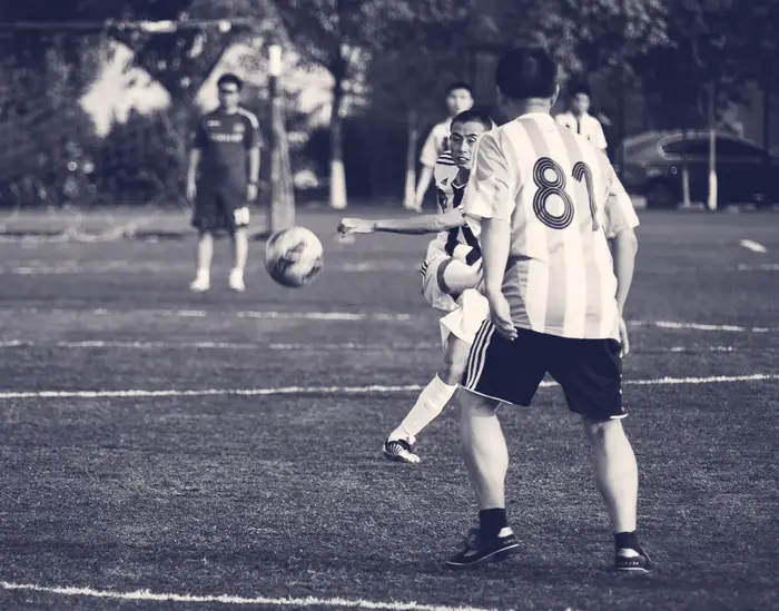 Young men playing an amateur football match on an artificial pitch